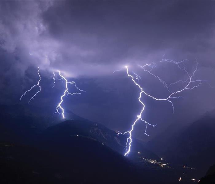 Mountains with streaks of lightning flowing across the sky