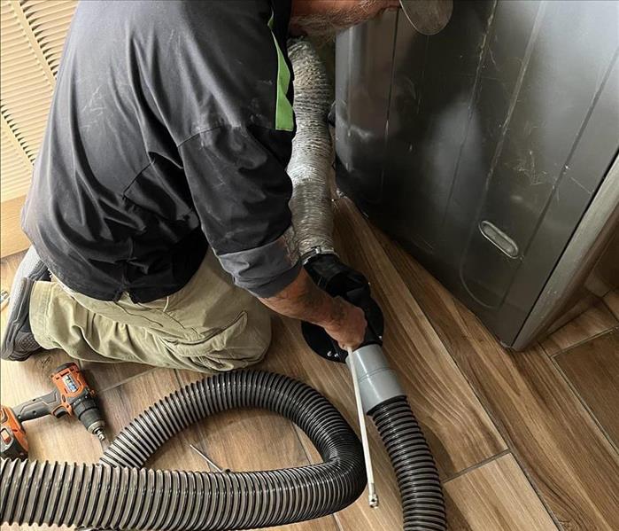 A Servpro of Casper employee cleaning a customers dryer vent. 